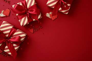 Festive Valentine's gift boxes with red ribbons and hearts on a red background.