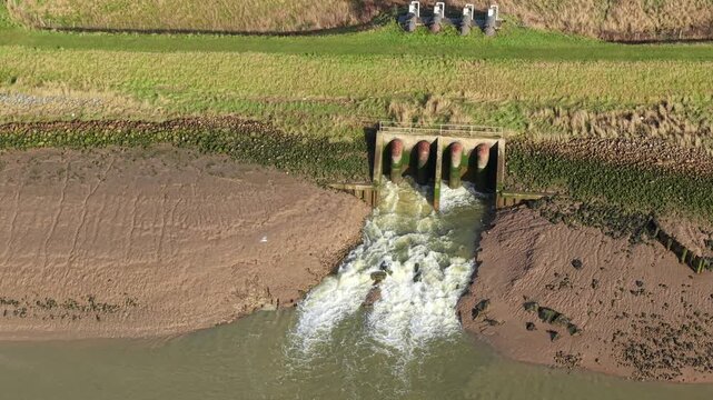 Close Up Aerial View of Massive Outfall Pipes Discharging Water into River Haven from Hobhole Pumping Station in Lincolnshire UK 4K Drone