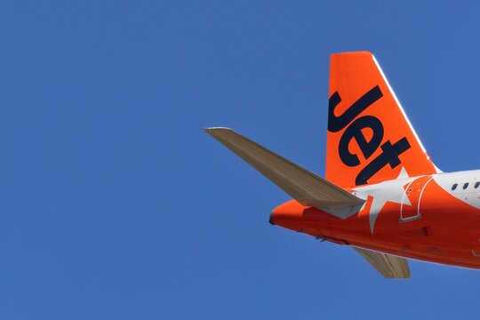 Perth, Western Australia, Australia - November 29 2025: Jetstar Airways airline, airplane tail fin, or empennage, with logo. Clear blue sky, copy space. Rear assembly providing stability and control