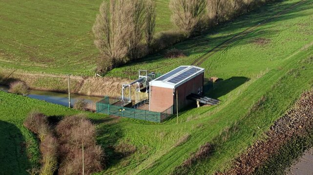 Aerial drone view of a rural water pumping station and flood management structure draining agricultural farmland in Boston, Lincolnshire, England UK.