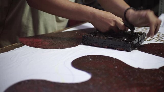 Close-Up of Traditional Batik Stamping Process on White Fabric
