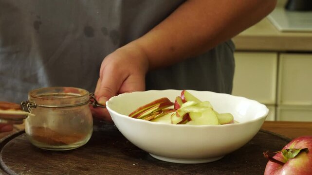Woman cuts apples and pears for pie
