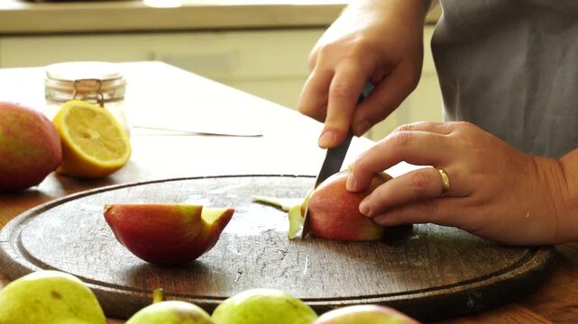 Woman cuts apples and pears for pie

