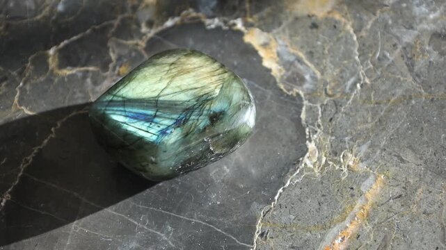Polished labradorite stone spinning on marble surface