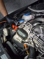 Fototapeta premium Oil and filter change on an old Skoda car. Close-up shots of motor oil pouring, filter replacement, and engine bay during routine garage maintenance Focus on precision.