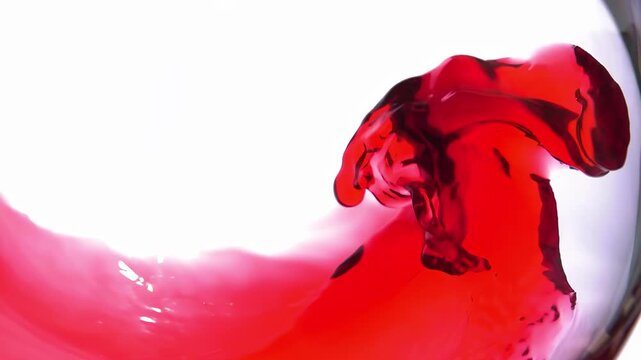 Red wine pours into a glass, creating an attractive wave. Grape juice. Pomegranate juice. High quality 4k footage
