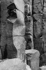 The image is a black and white photo of a rocky cliff