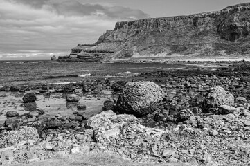 A rocky shoreline with a large rock in the foreground