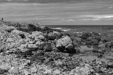 A rocky shoreline with a few people standing on it