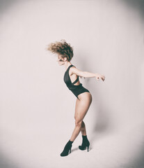 Sportliche Frau in dynamischer Dehn- und Sprungpose im Studio. Kombination aus Yoga, Pilates, Tanz und Ballett. Ausdruck von Kraft, Balance, Beweglichkeit und Körperkontrolle in moderner Ästhetik. © fotoak80