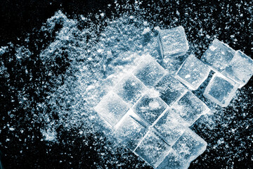 Ice cubes with a ice crush and snow on black background.