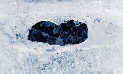 Hole in the textured natural ice.