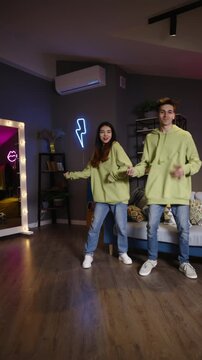 Dynamic camera move reveals phone tripod as teen dancers film synchronized short form dance video for social media platforms