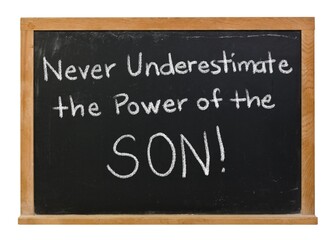 Obraz premium Never underestimate the power of the sun son handwritten in white chalk on a black chalkboard isolated in a wooden frame on white