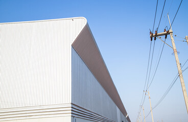 Obraz premium Factory industry, Architecture Building with Aluminium Facade on Blue Sky Background, Backdrop Wall Metal Corrugated Steel Surface Pattern, Warehouse Construction in Geometric Modern Design