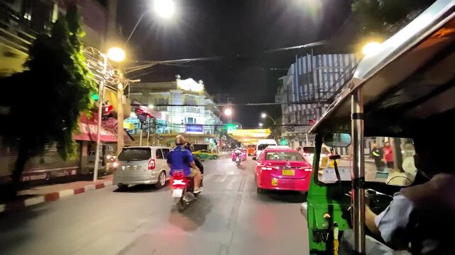 BANGKOK, THAILAND - DECEMBER 16, 2019: Night city traffic in slow motion, view from moving Tuk-Tuk