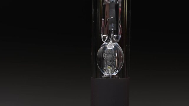 Extreme macro close-up of a xenon gas bulb. Close-up of a xenon headlight bulb. Rotating bulb on a gradient gray background.