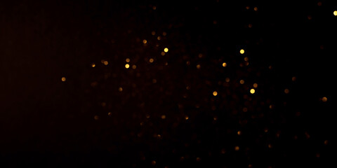 Golden abstract bokeh on black background.