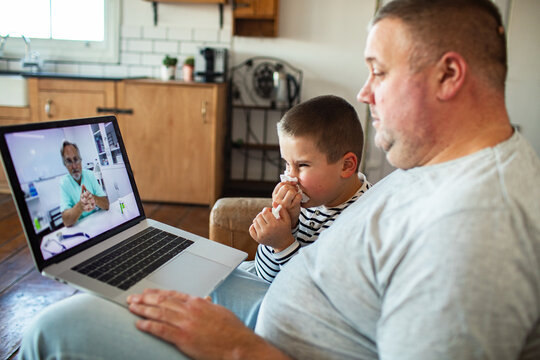 Father and sick child on telemedicine video call at home