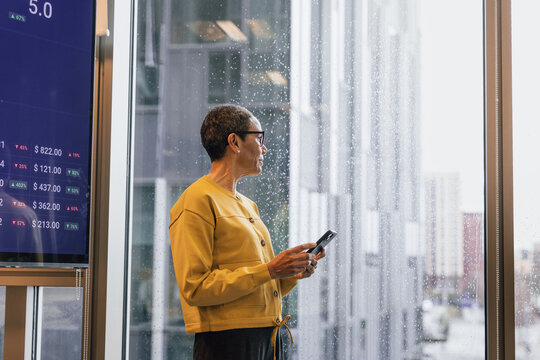 Female Trader looking out a Window on a Rainy Day
