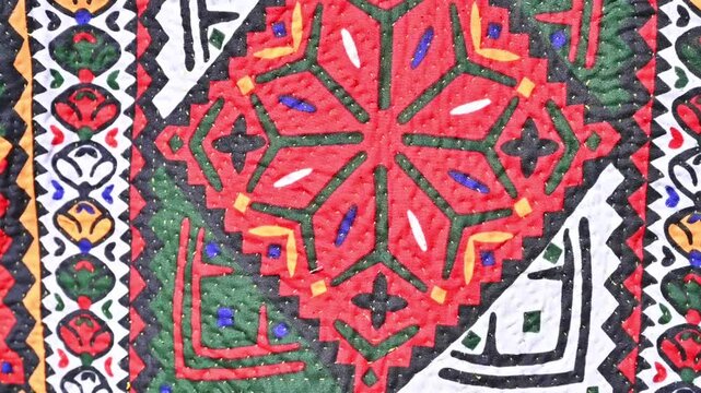 This is a close-up of a traditional, handmade Sindhi Ralli quilt featuring vibrant patchwork and appliqu&eacute; work 