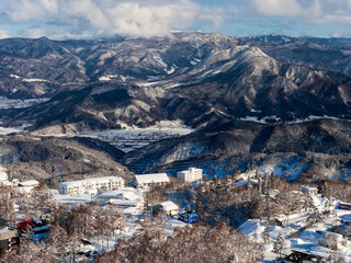 Scenic winter landscape in Nagano featuring snowy peaks and a mountain village