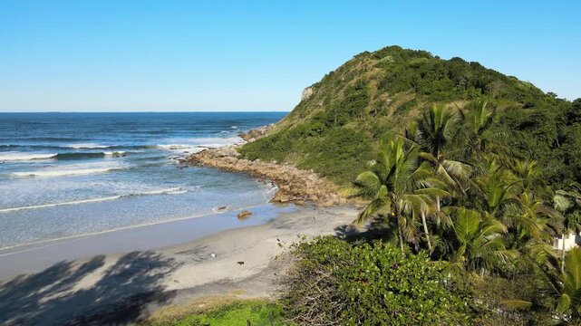 Voo sobre Ilha do Mel no litoral do Paran&aacute; em Parangu&aacute; com mar e c&eacute;u azul na praia de fora na mata atl&acirc;ntica mostrando o farol das conchas