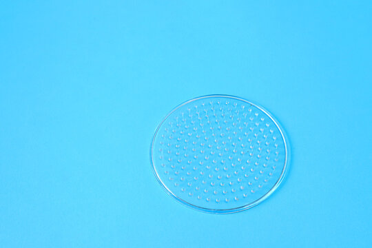 one plastic round perler bead pegboard on blue background for crafts and thermal beads