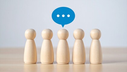 Row of Miniature Wooden Figures with Blue Chat Speech Bubbles for Team Communication, Social Networking, and Public Opinion Concept
