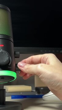 Female hand switching different modes on gaming microphone 