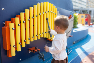 Baby playing music instrument at outdoor kids park