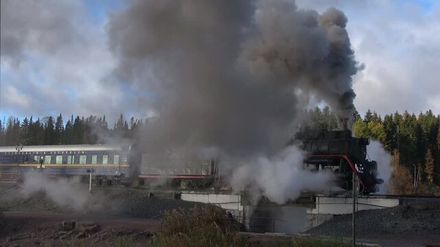 Old Soviet locomotive with retro train leaving from station