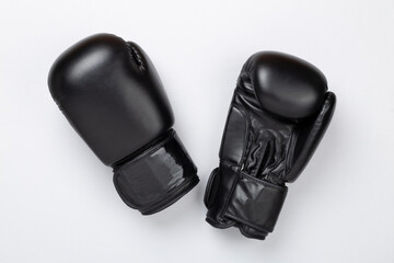 Black boxing gloves on color background, top view