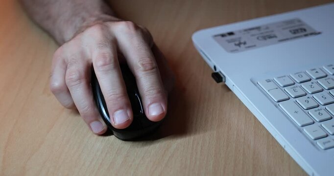 Hand Using Mouse While Working on Laptop, Close-Up of Computer Workspace