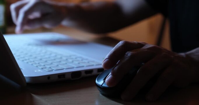 Hand Using Mouse While Working on Laptop, Close-Up of Computer Workspace
