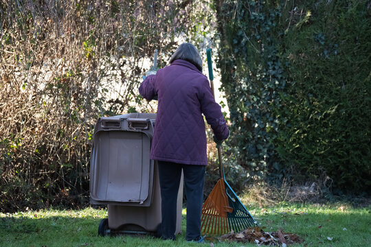 Femme jardinant de dos avec un r&acirc;teau