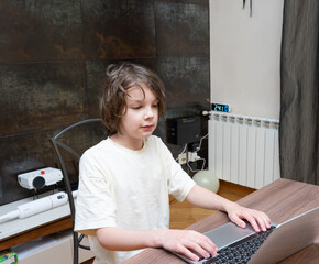 Young boy using laptop computer at home. Kid typing on keyboard for online study