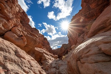 Fototapeta premium Sunlight Streams Through a Narrow Desert Canyon Under a Blue Sky.