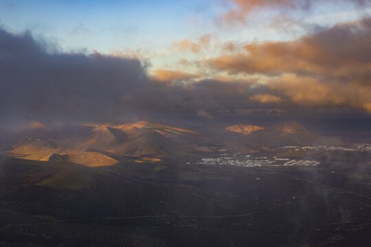 Panorama at sunrise from the Montana de Guardilama to the wine-growing area La Geria, behind it the villages Uga and Yaiza, Lanzarote, Canary Islands, Spain