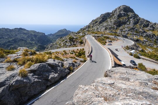 Road cyclists at the mountain pass with serpentines to Sa Colobra, Nus de Sa Corbata road loop, Serra de Tramuntana, Majorca, Balearic Islands, Spain