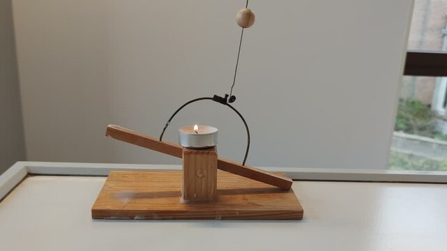 Physics lesson at school where the expansion of bimetal under the influence of heat is demonstrated using a seesaw.