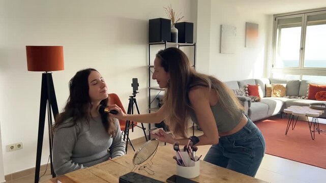 Amiga maquillando a influencer en su set de grabaci&oacute;n en el sal&oacute;n