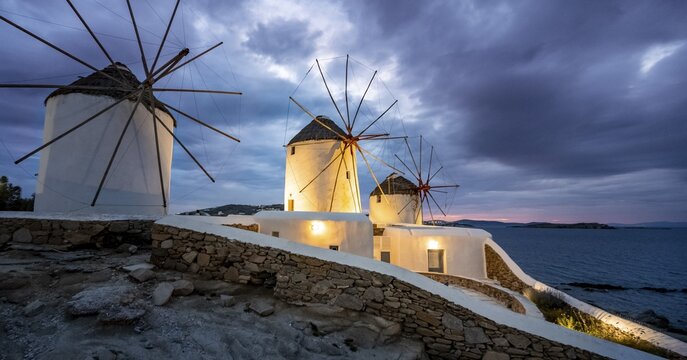 Illuminated windmills, Kato Milli, at sunset, dramatic cloudy sky, Mykonos Town, Mykonos, Greece