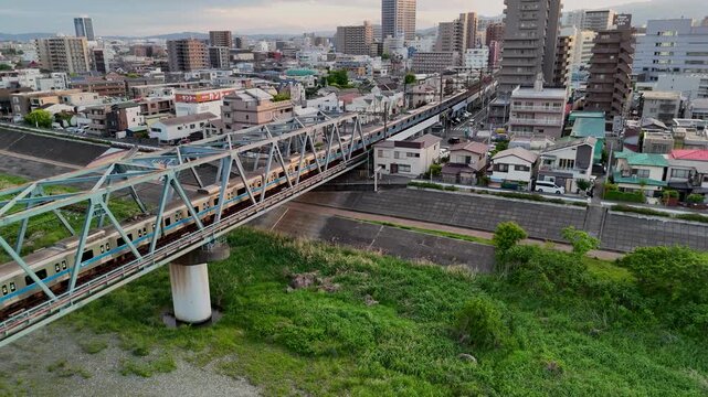 Drone shot of Odakyu Line local train traveling over a railway bridge.  
