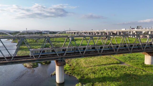Aerial view of commuter train crossing a bridge in Japan. 
