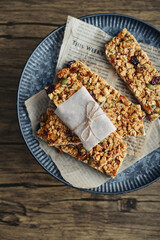 Gluten-free oat granola bars with nuts and berries on round vintage metal tray