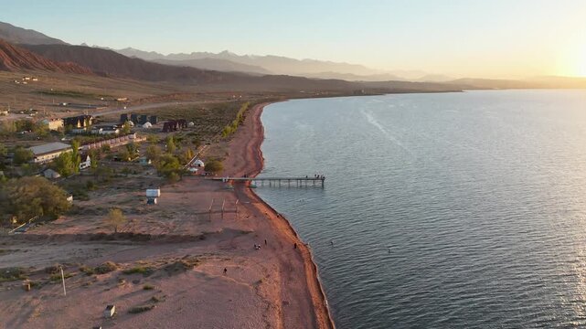 Stunning drone view of Issyk-Kul Lake at sunset, showcasing golden skies