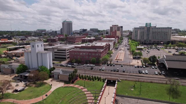 Drone shot wide aerial shot of downtown cityscape of capital city Montgomery, Alabama in deep south of America, including government buildings, riverfront, residential apartments, and car traffic