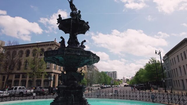 Large circular water fountain waterfalls in the center of a street roundabout car road with traffic at downtown travel destination and capital city in deep south United States of Montgomery, Alabama