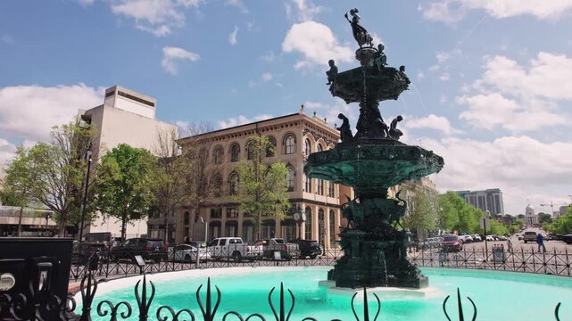 Large circular water fountain waterfalls in the center of a street roundabout car road with traffic at downtown travel destination and capital city in deep south United States of Montgomery, Alabama